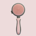 Green and pink two-sided silicone pet grooming brush with slicker brush and massage head on a white background