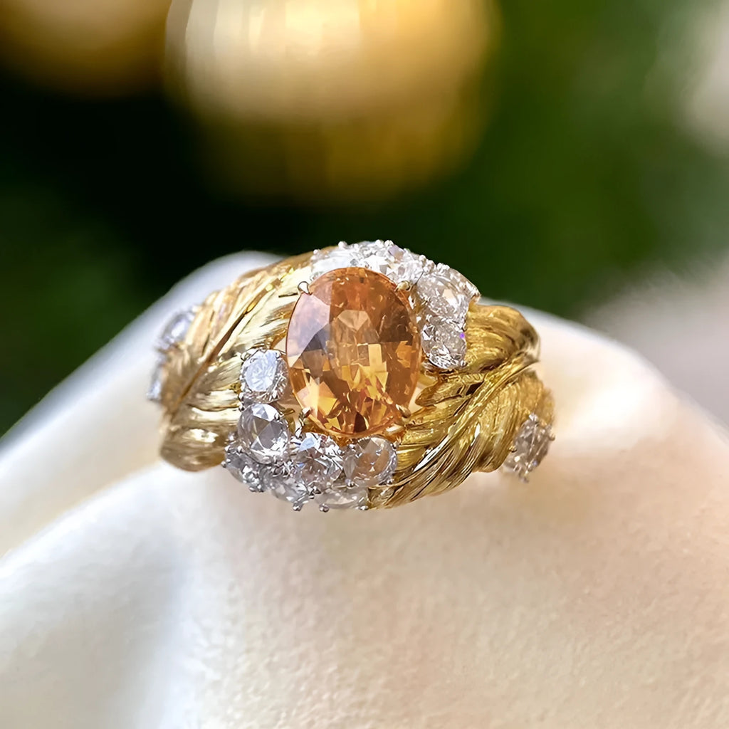 Gold feather embossed women's ring with a yellow zircon stone on a geometric copper band.