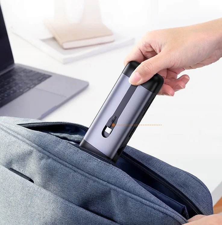 Silver USB laptop docking station with HDMI, USB 3.0, and charging ports on a desk.