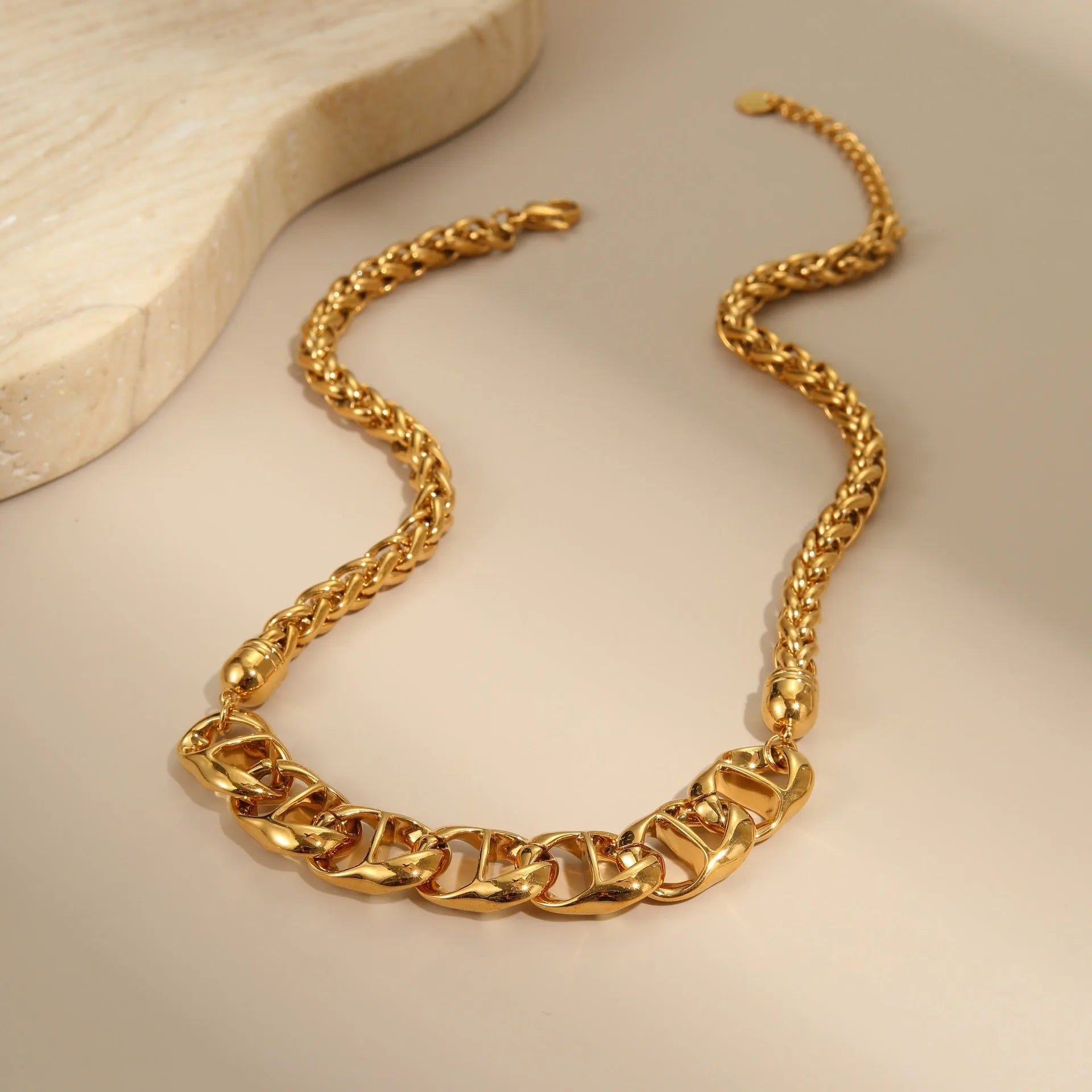 Stainless steel geometric pendant necklace with gold electroplated finish on a regular chain.