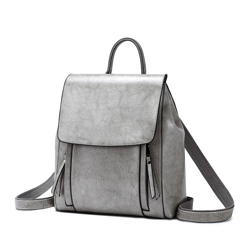 Genuine oil-waxed cowhide leather women's backpack in black, showing soft straps, cover flap, and clean stitching.