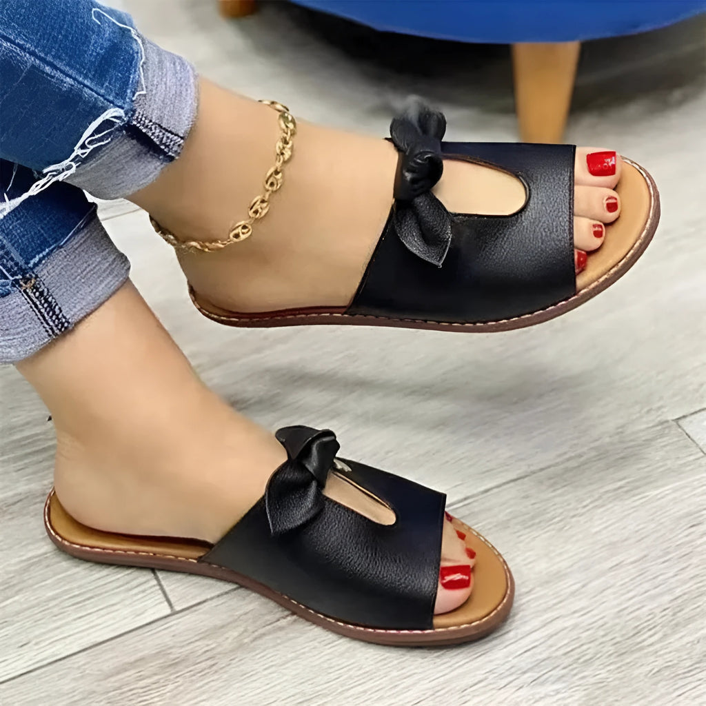 Women's black fishmouth sandals with a decorative bow on the strap, showing the open toe and rubber sole.