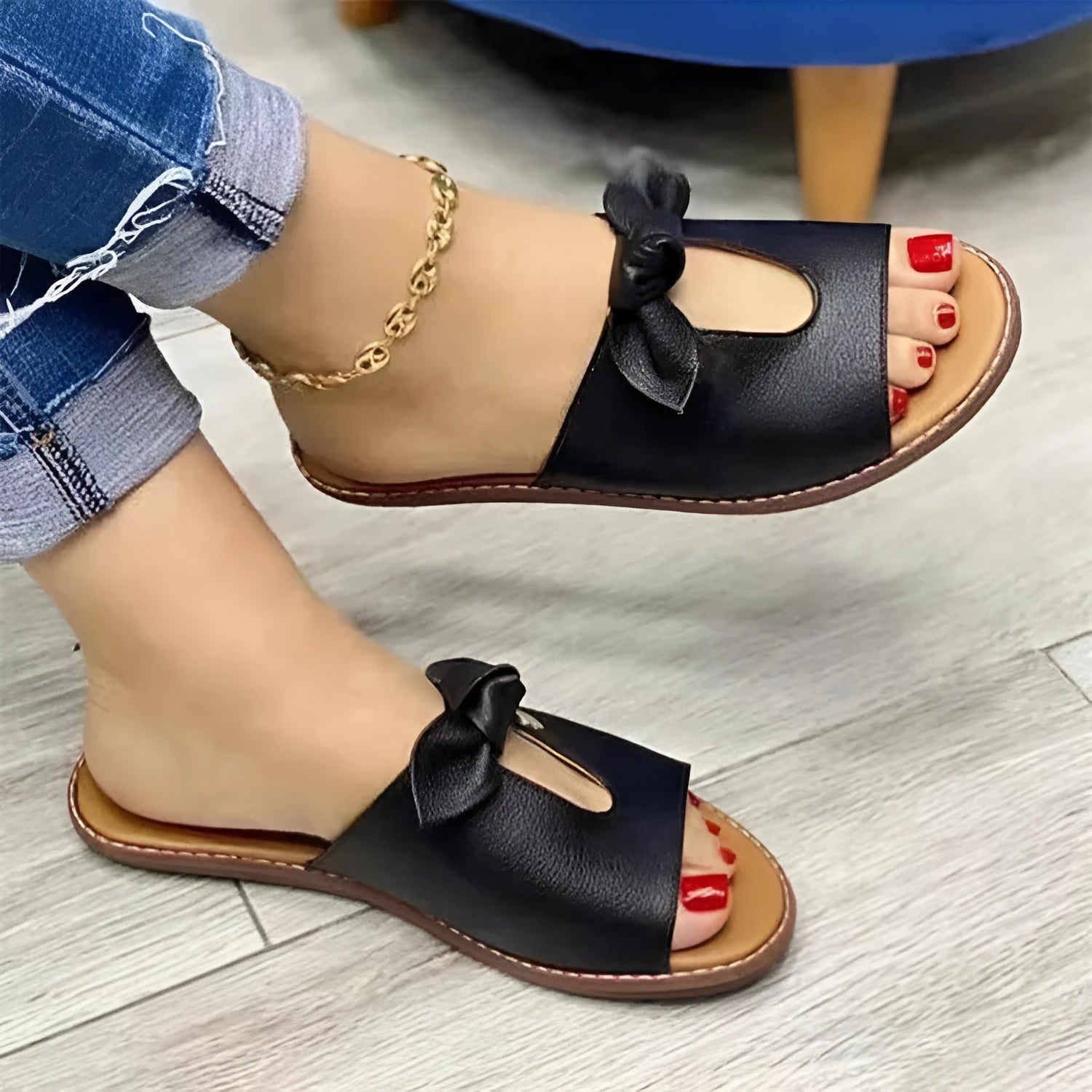 Women's black fishmouth sandals with a decorative bow on the strap, showing the open toe and rubber sole.