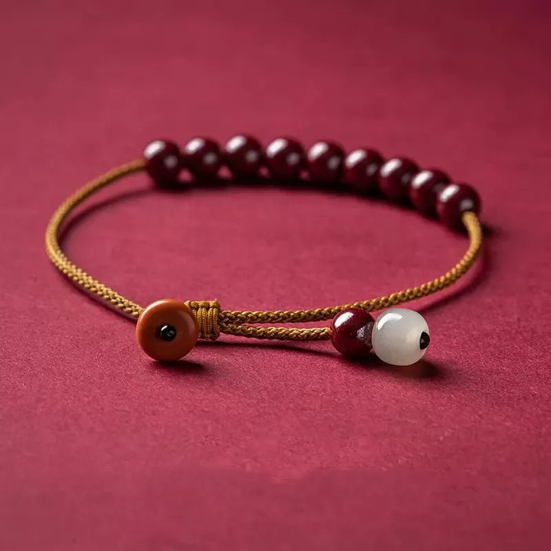 Hand-woven bracelet made of red cinnabar and raw Hetian Jade in a simple geometric shape.