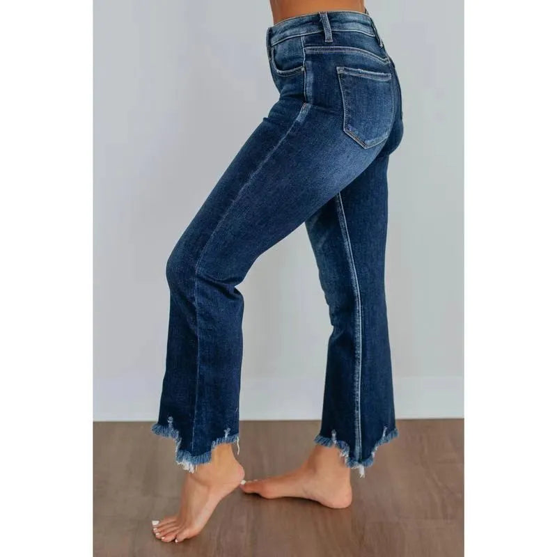 A pair of women's solid colour denim trousers with a manual wear finish, shown in dark blue.