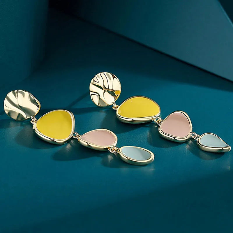 Sterling silver alloy Morandi three-colour oil drip simple wafer disc earrings on a white background.