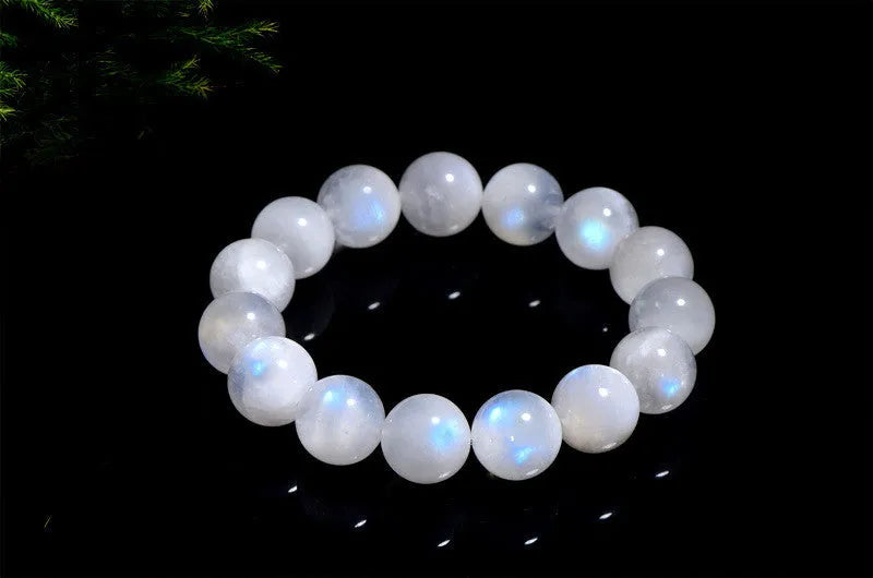 Natural blue moonlight round moonstone bead bracelet on a wrist, showing adjustable closure.