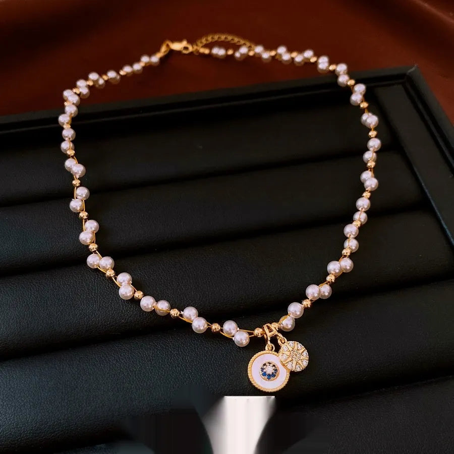 Gold electroplated adjustable clavicle necklace with round zircon and imitation pearl pendant.