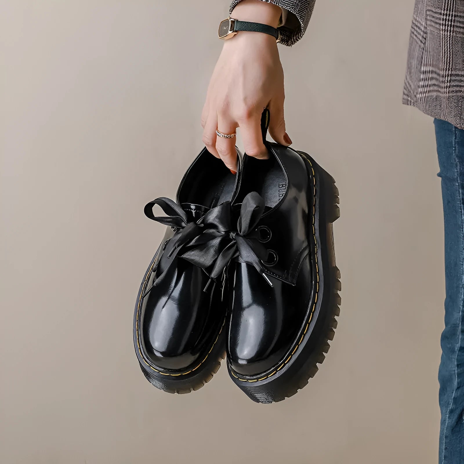 Black and white women's thick-soled leather shoes with ribbon cross straps and laces.