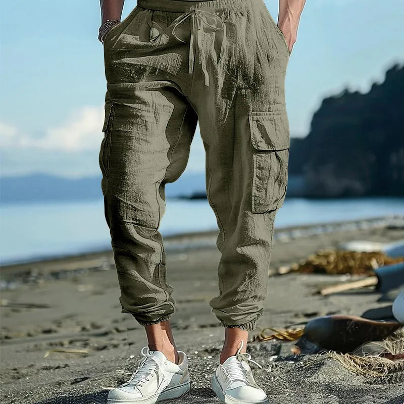 Man wearing khaki linen casual trousers with ankle-tied cuffs and multiple pockets.