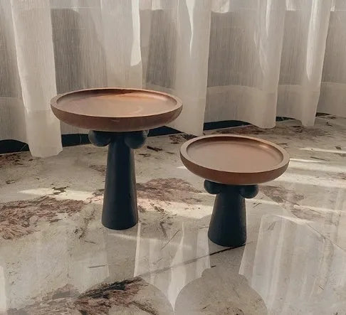 Nordic style round wooden tray with high legs for displaying candles and aromatherapy items.