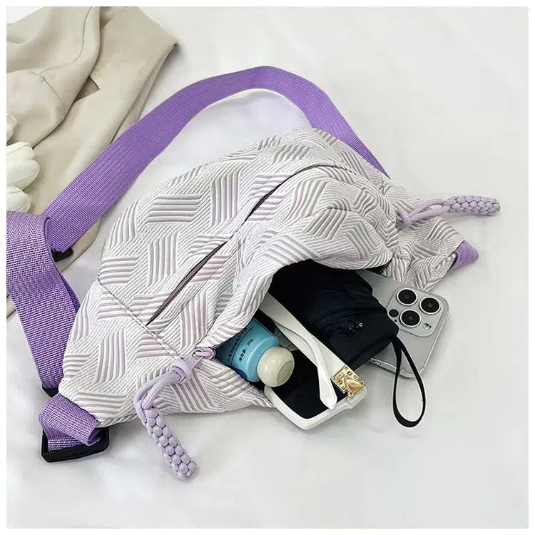 Nylon dumpling-shaped crossbody bag with single strap, zip hidden pocket, and inner patch pocket in pink, green, yellow, or purple.