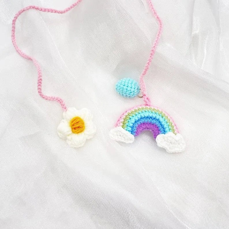 Handmade crocheted wool car pendant in avocado, pink rainbow, or red rainbow colour with cartoon flower design.