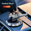 Silver metal solar-powered helicopter car air freshener rotating on a car dashboard.