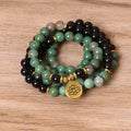 Green and black alloy beads on an elasticated bracelet, shown on a wrist.