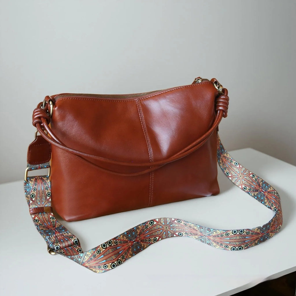 Genuine leather pillow-shaped commuter bag in caramel colour with double straps and patchwork detailing, 31x11x24cm