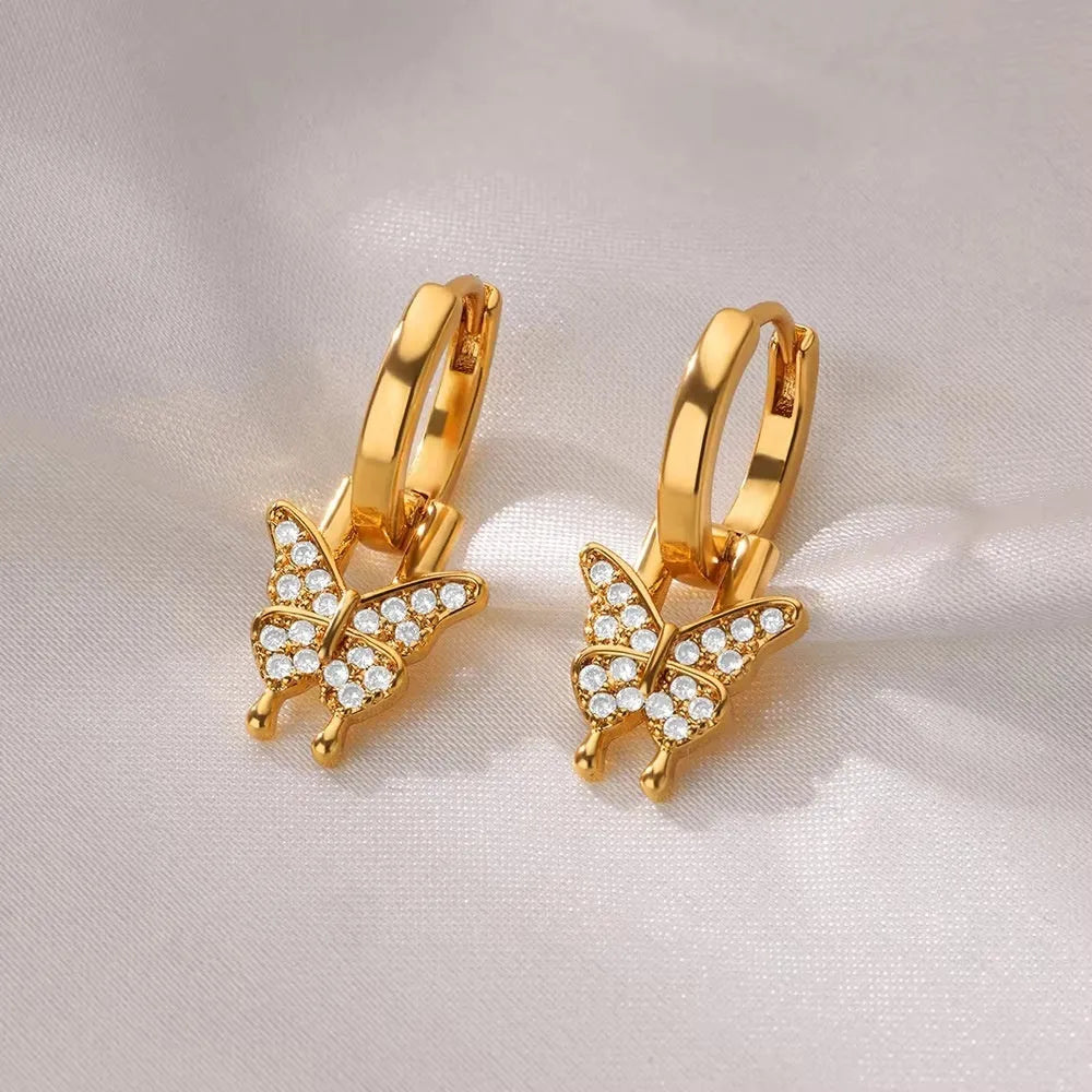 Women's geometric butterfly-shaped copper earrings with heart and star details in various colours.