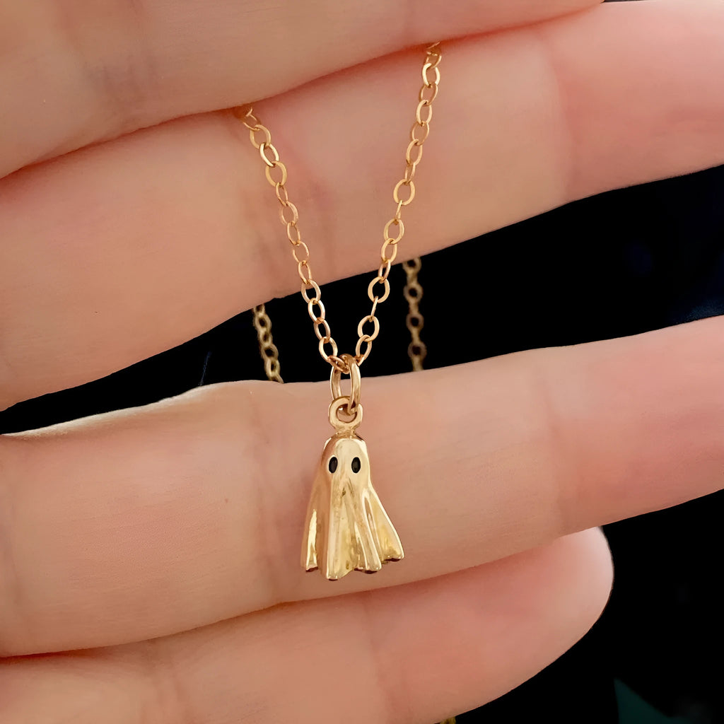 A modern ghost pendant necklace on a stainless steel chain, showing the titanium steel electroplated pendant detail.
