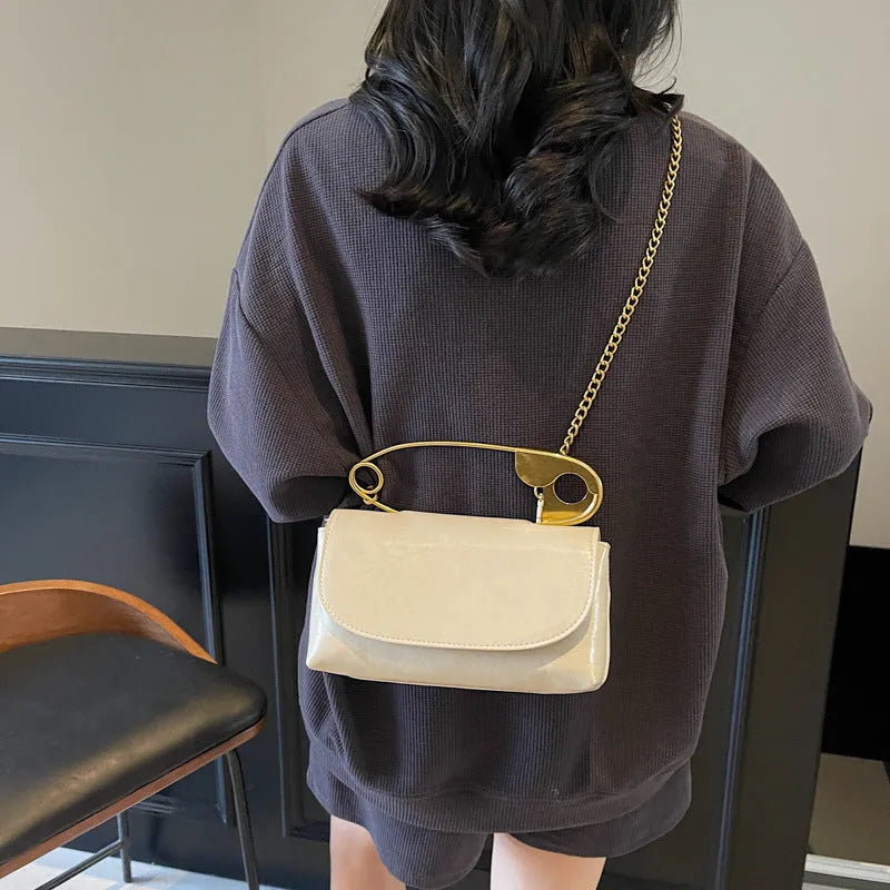 Creative personality paper clip shoulder handbag in PU leather with sandwich pocket and file bag interior.