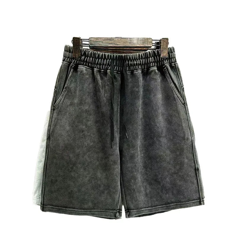 Men's loose-fit cotton shorts with a distressed finish in charcoal black, shown in a straight-leg style