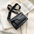 Vintage style black crossbody bag with an adjustable shoulder strap on a mannequin.