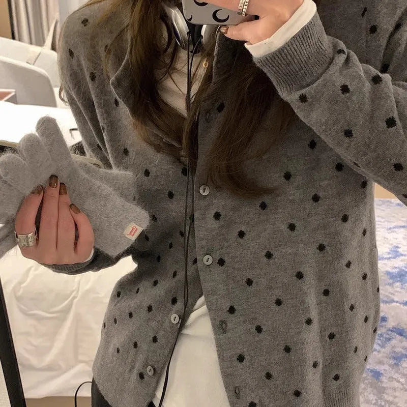 Women's grey dot knitted cardigan with crocheted flower detail on front, shown in loose fit.