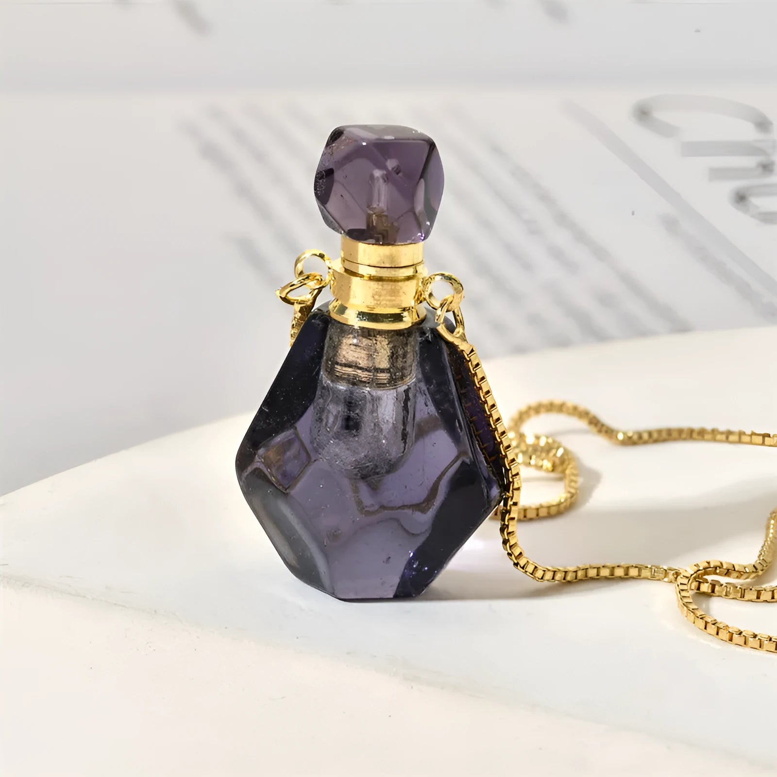 Semi-precious amethyst perfume bottle pendant necklace with alloy chain on neutral background