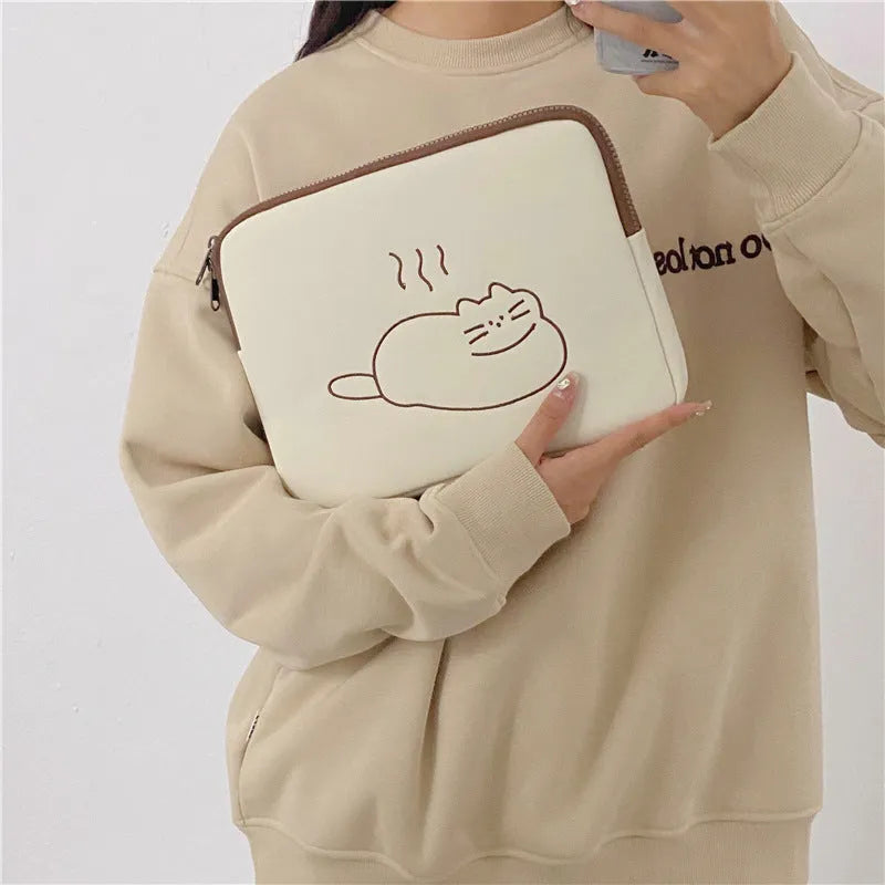 Embroidered fat cat design on a grey nylon tablet protective sleeve with a black metal zipper.