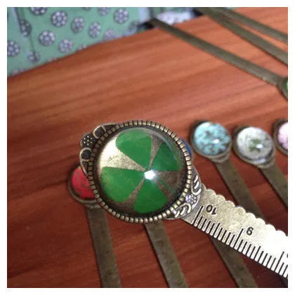 Handmade dried gypsophila and clover flower bookmark ruler on a book, showing 12cm length.