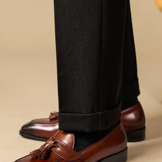 Men's black genuine leather tassel loafers with a polished finish and rubber sole.