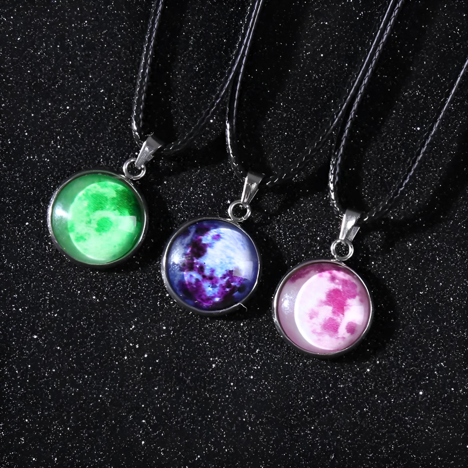 Luminous moon and star constellation pendant necklace with a silver-tone chain on a black background.