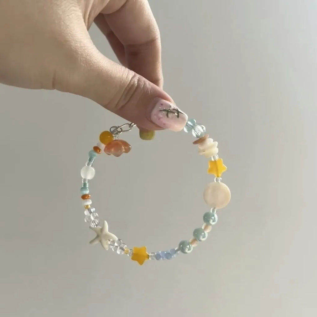 Orange sea colour summer bracelet with diamond shape and round mixed-material elements on wrist