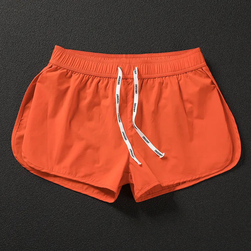 Men's loose fit beach shorts in orange, fluorescent green, and black colours with stretch polyester fabric