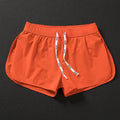Men's loose fit beach shorts in orange, fluorescent green, and black colours with stretch polyester fabric
