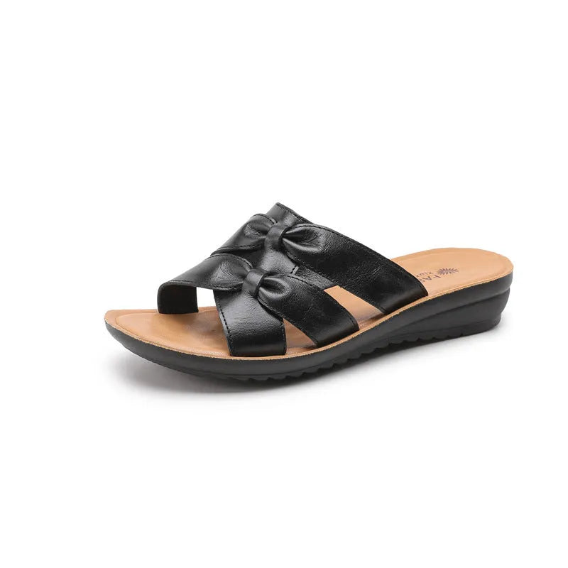 Beige women's cowhide slippers with a soft non-slip sole on a plain background
