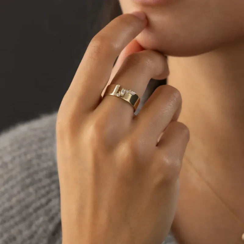 Gold-coloured women's ring with shining zircon stones on a copper band.