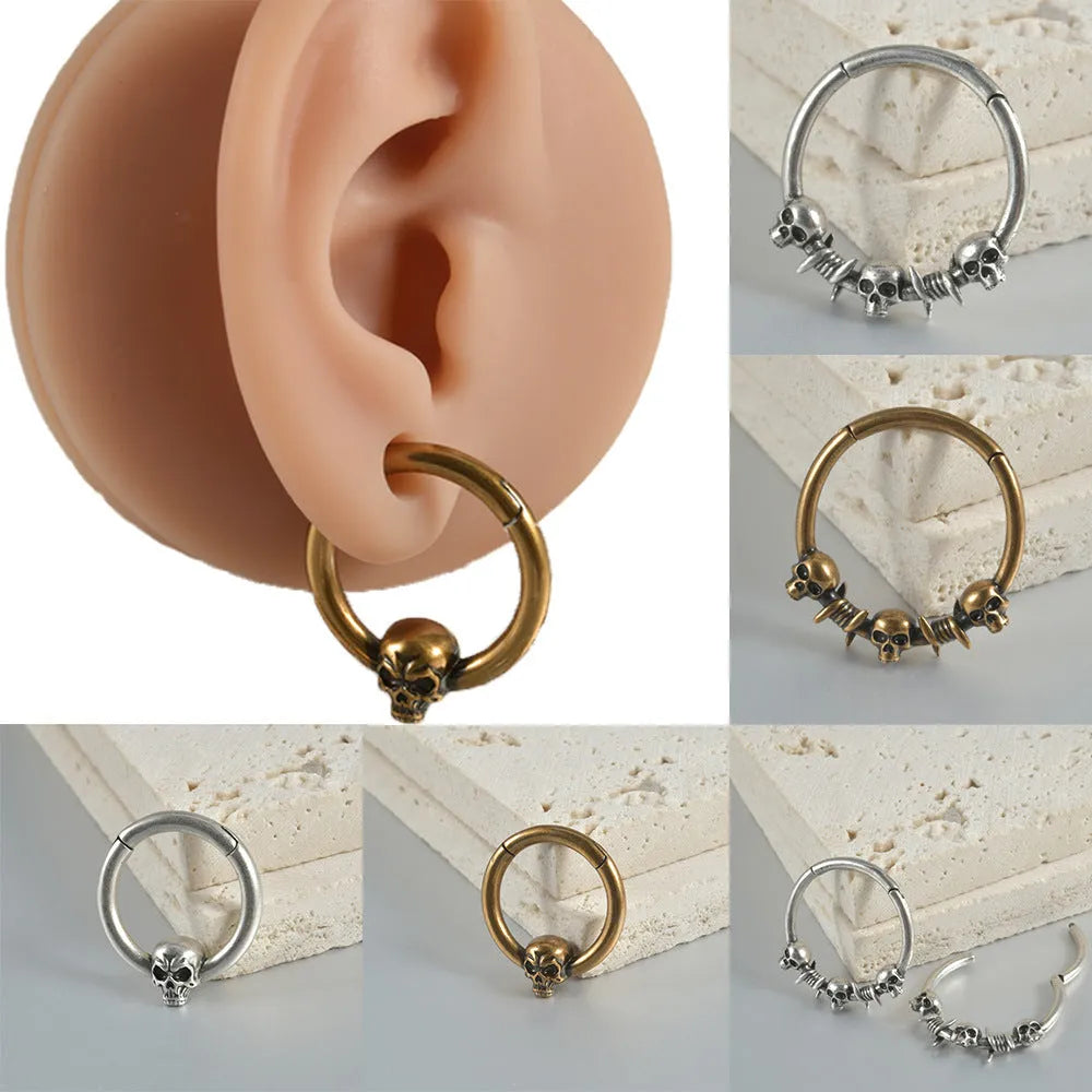 Close-up of vintage-style copper stud earrings featuring a detailed stamped ghost head motif with an antique silver finish.