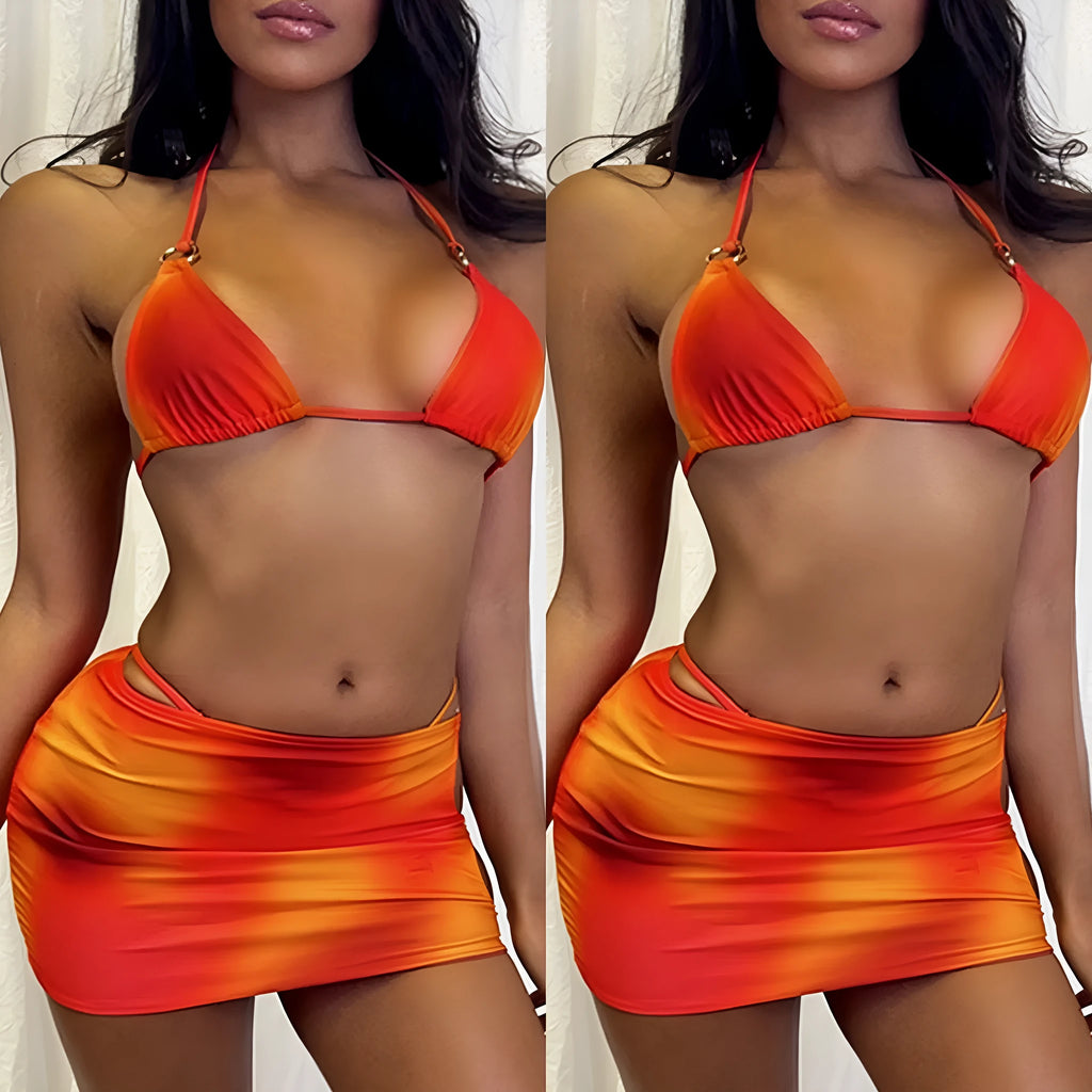 Tie-dye gradient three-piece swimsuit set with halter neck top, bikini bottoms, and matching skirt on a neutral background.