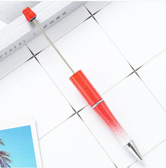 Colourful spinning ballpoint pen with plastic beads on a white background.