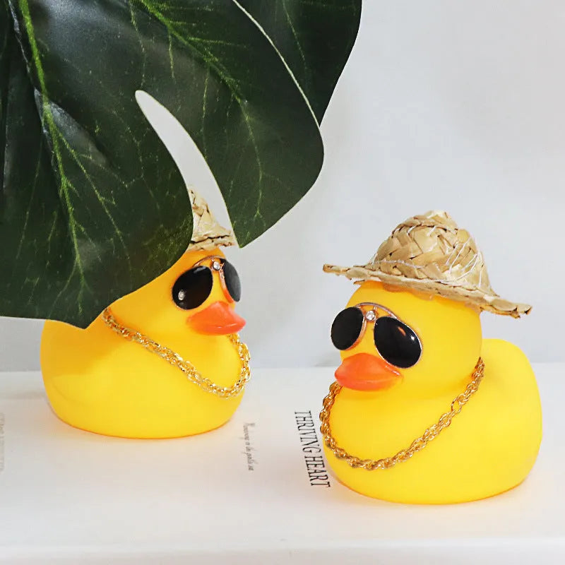 Yellow duck car ornament with straw hat and sunglasses on car dashboard
