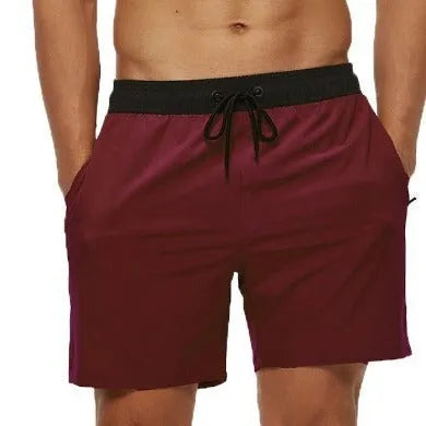 Men's blue stitching waist athletic shorts with a drawstring and zipper pocket, shown on a model.
