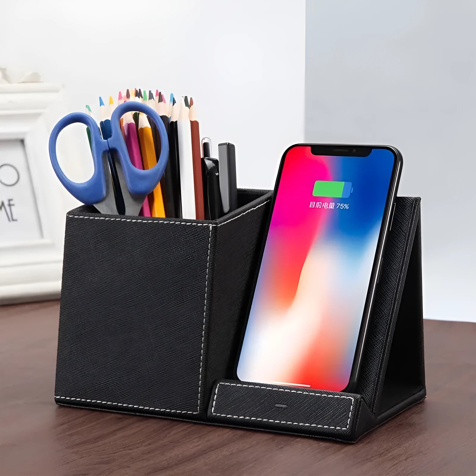 Black leather desk organiser with pen slots and a wireless phone charging pad on top