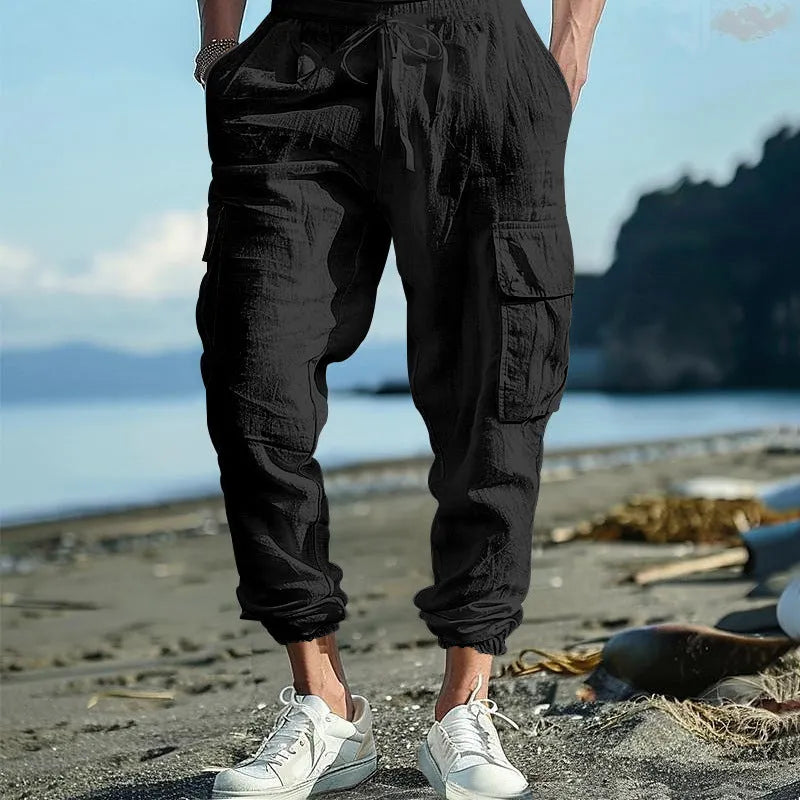 Man wearing khaki linen casual trousers with ankle-tied cuffs and multiple pockets.