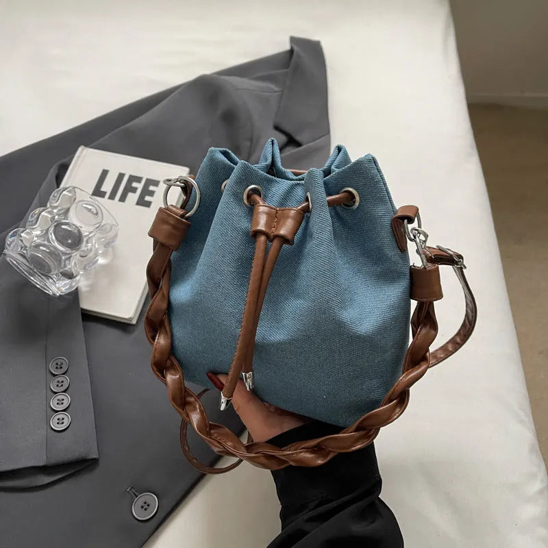 Blue synthetic leather cross body bucket bag with sandwich pocket construction
