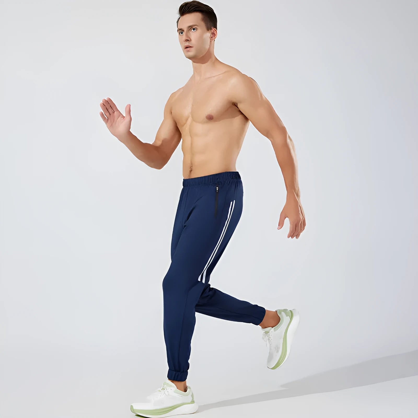 Black men's running trousers with a mid waist, laid flat to show the trousers length and sporty design.
