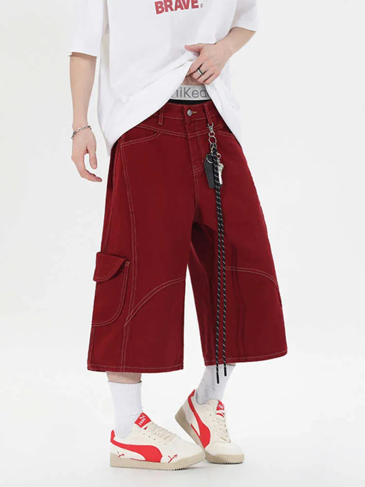 Men's red denim wide-leg cropped workwear shorts with multiple pockets on a mid waist