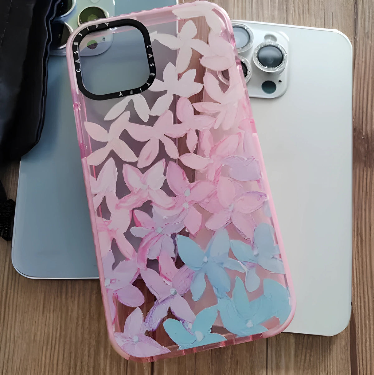 Transparent TPU phone case for iPhone 12 and 14 Pro Max with pink and blue petal pattern.