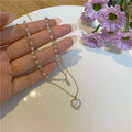 Gold-tone zinc alloy double-layer necklace with heart-shaped pendant and adjustable 21-50cm regular chain for women.