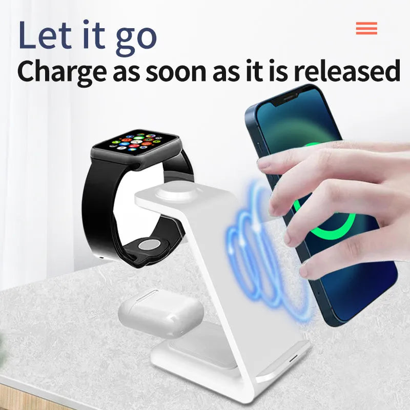 White 3-in-1 wireless charging stand holding a mobile phone, smartwatch, and earbuds on a wooden desk.