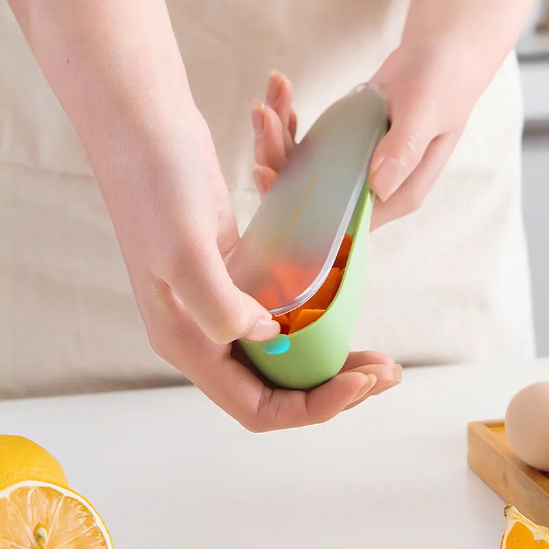 Green fruit and vegetable peeler with a stainless steel blade, plastic handle, and a separate white storage tube.
